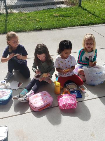 4 students eating lunch on lawn