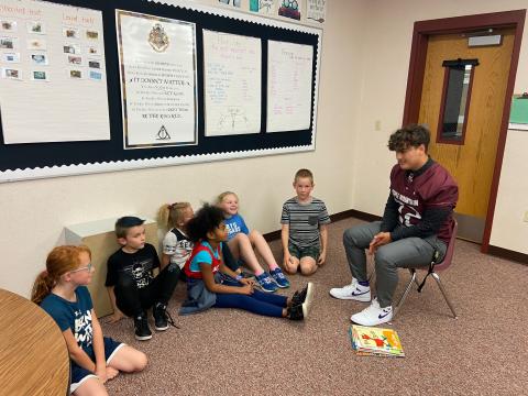 football players reading to students