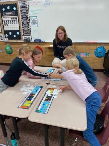 students doing math activities with helpers