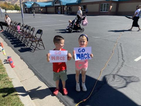 kids holding sign with Mack on it